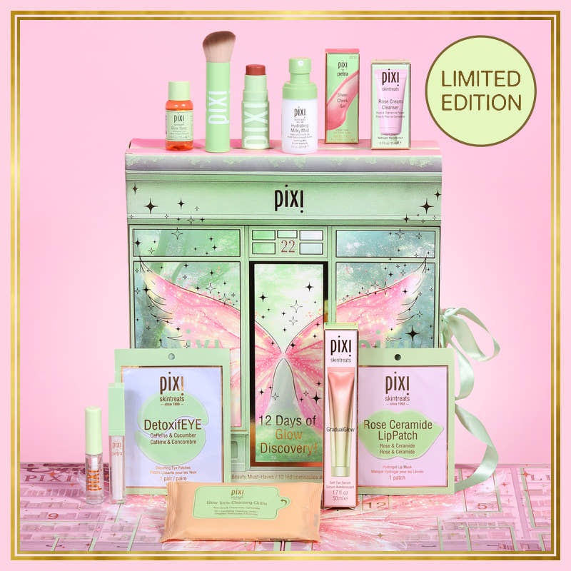 Pixi Limited Edition skincare set arranged in front of a decorative fairy-themed cabinet on a pink background. The set includes multiple Pixi products such as DetoxiEYE, Rose Ceramide LipPatch, and a lip treatment, with a green cabinet and pink fairy artwork.