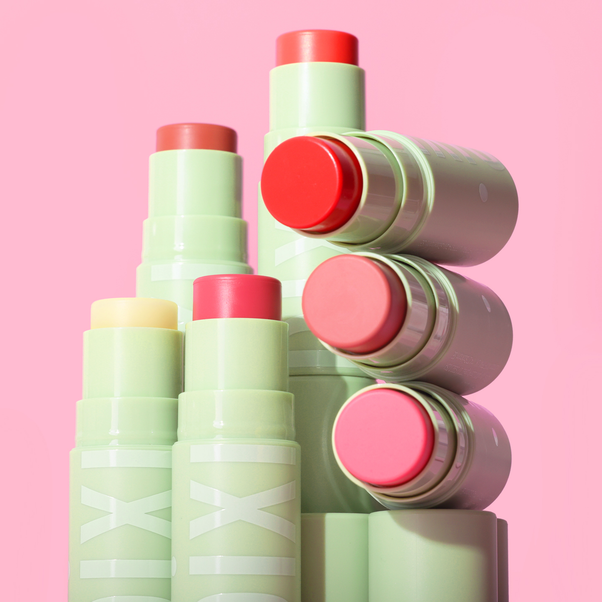 +Hydra LipTreat multiple shades on a pink background