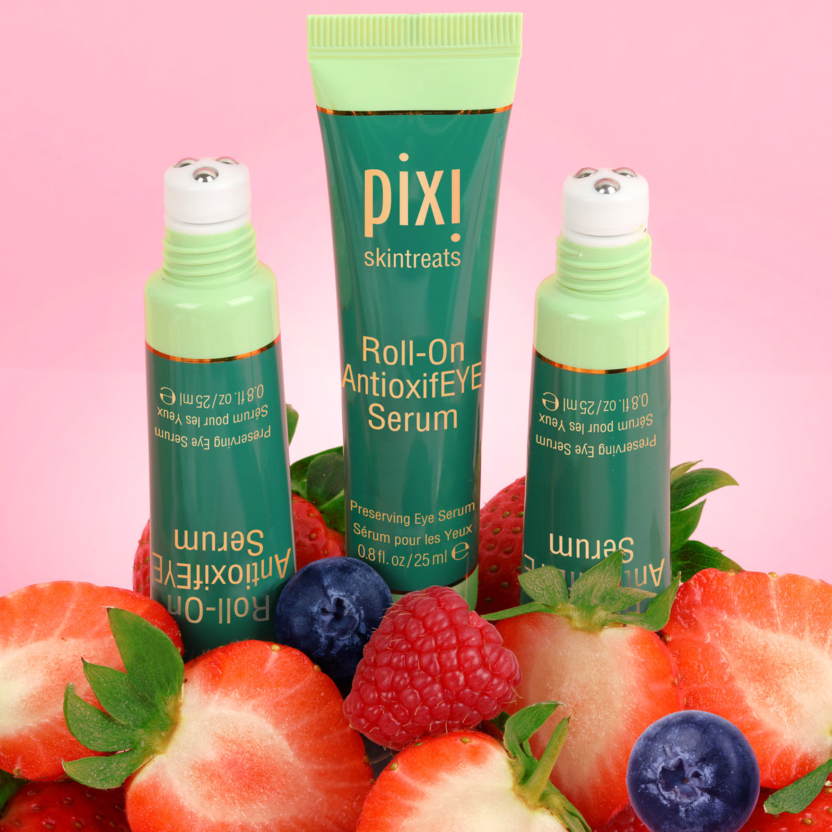 Pixi Roll-On Antioxidant Serum with strawberries and blueberries on a pink background