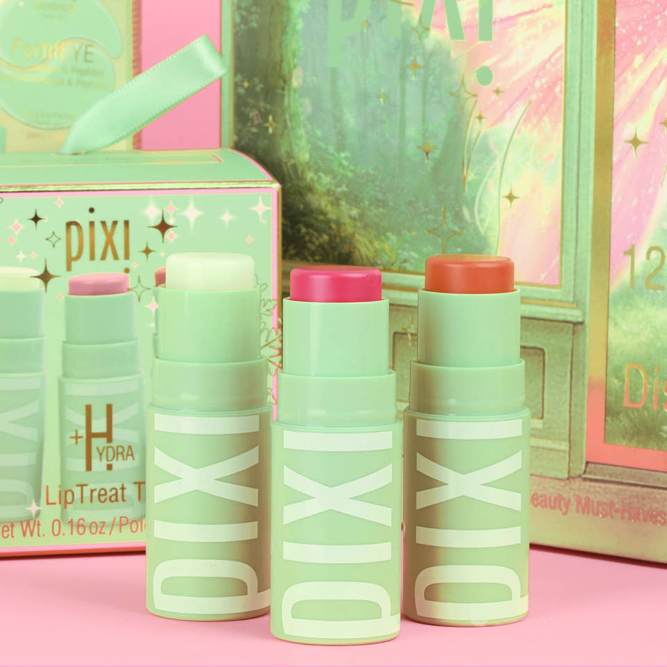 Three Pixi +Hydra liptreat lipsticks in mint green with pink, peach, and white caps, displayed in front of their colorful packaging on a pink surface. view 1